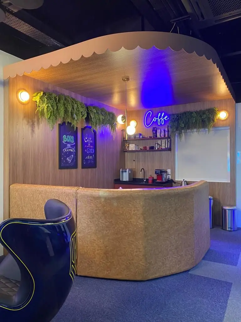 O balcão do café da Sala 09, com plantas no alto